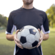man holding football on pitch