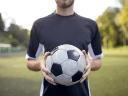 man holding football on pitch